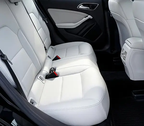 Clean white leather back seats of a luxury vehicle with black trim and modern design